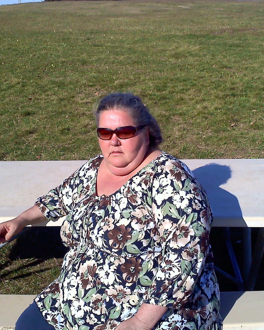 Jodi Isaacson before, seated outdoors at her heaviest
